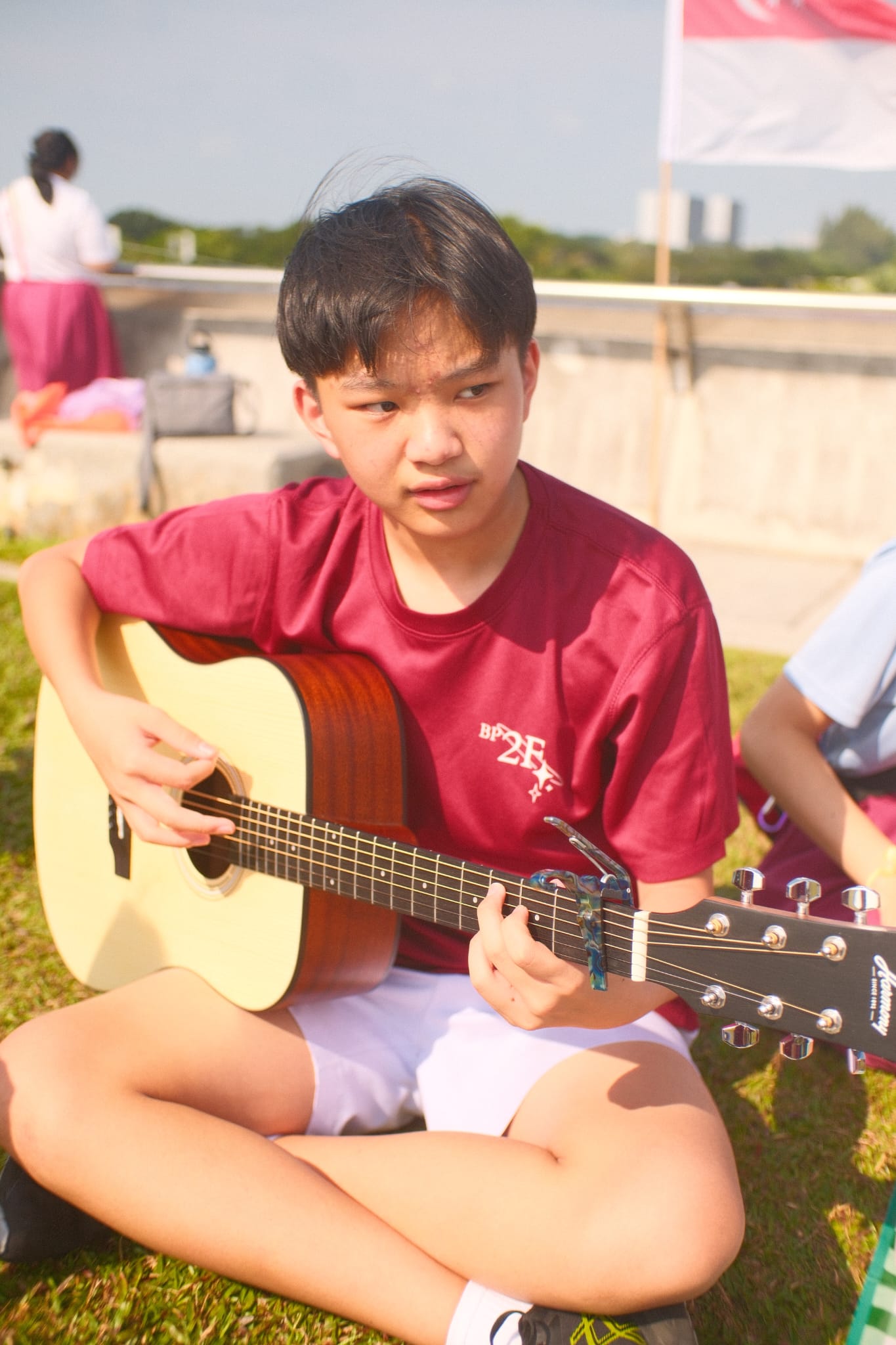 Ethan playing an acoustic guitar outdoors
