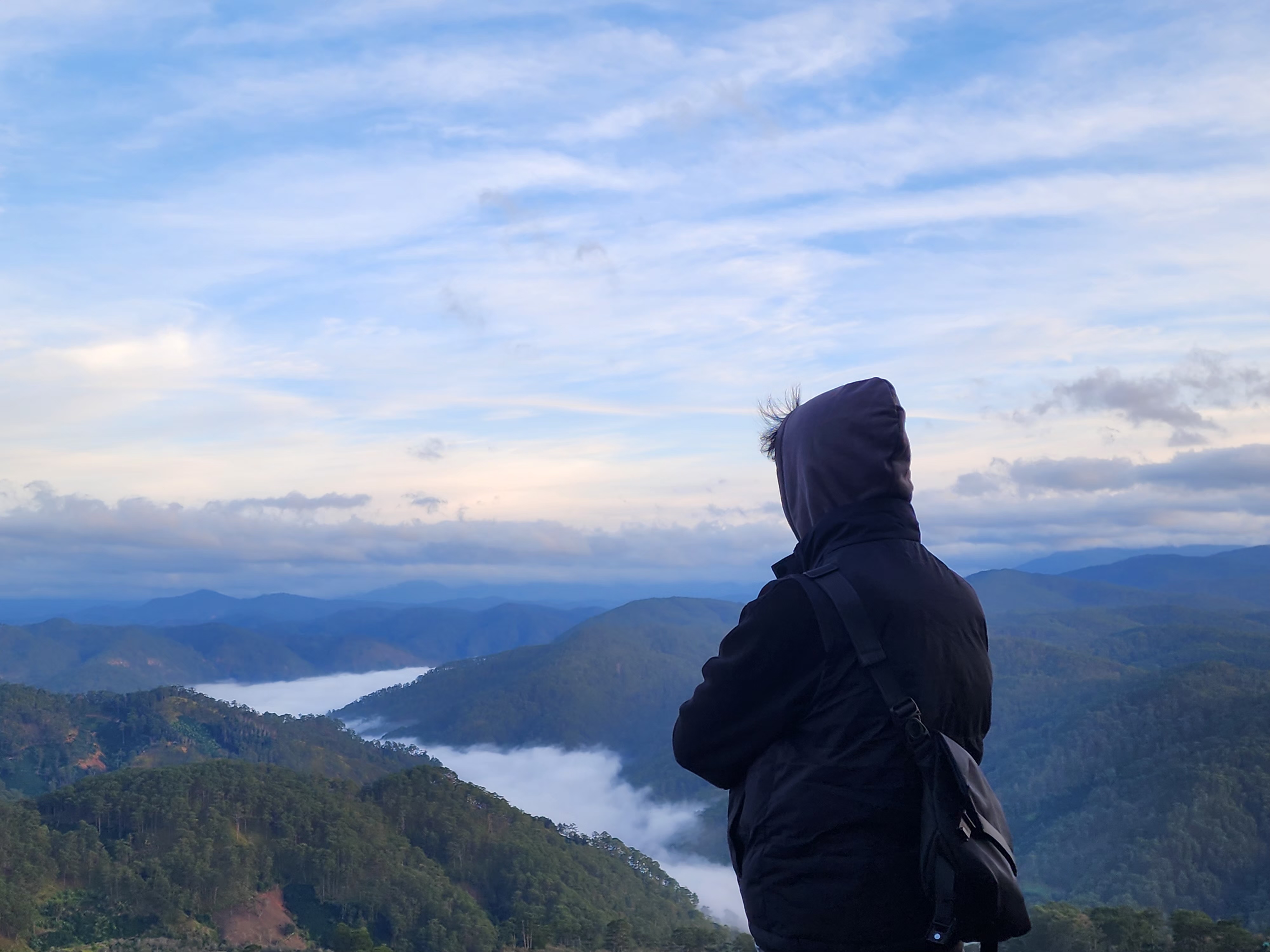 A quiet mountain overlook with a person standing near the edge
